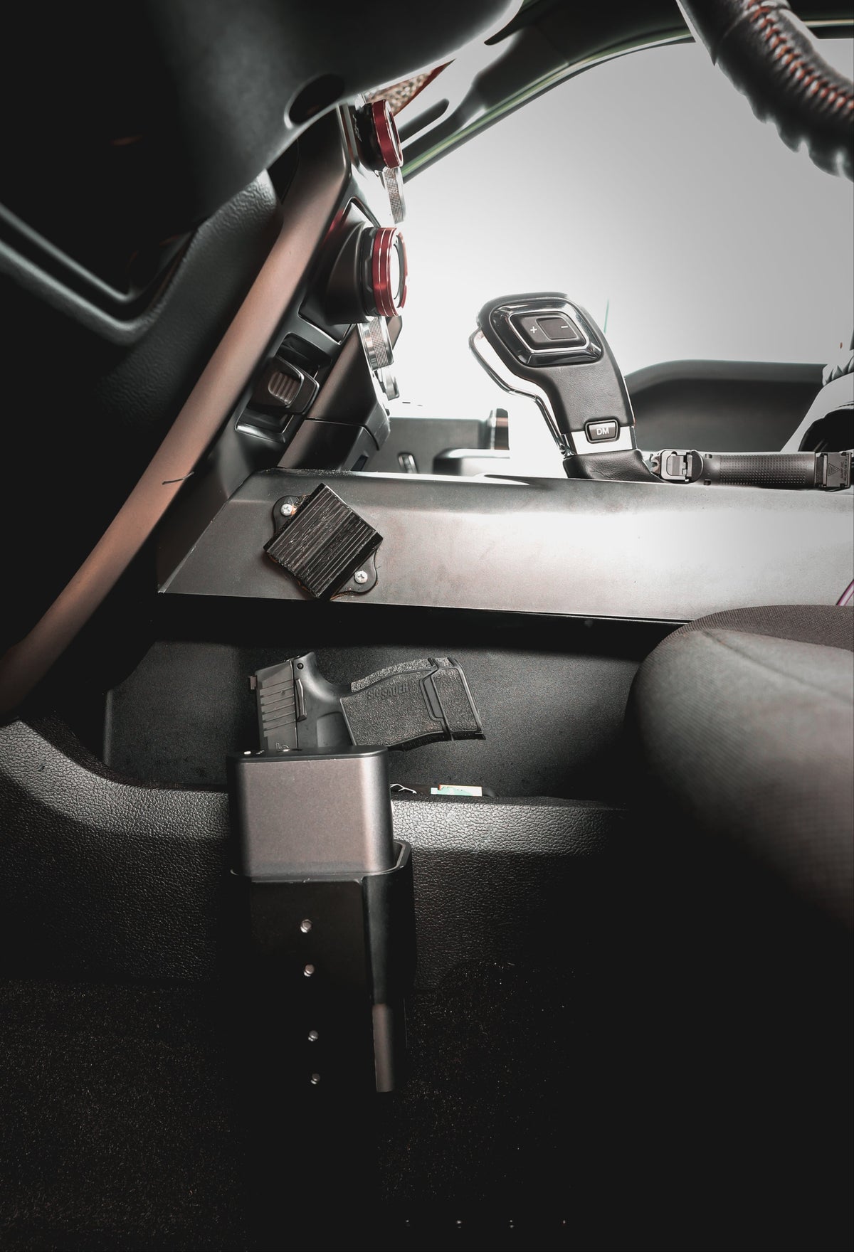 Reach 2S mounted under the dash as a quick-access car handgun safe holding a Sig Sauer pistol