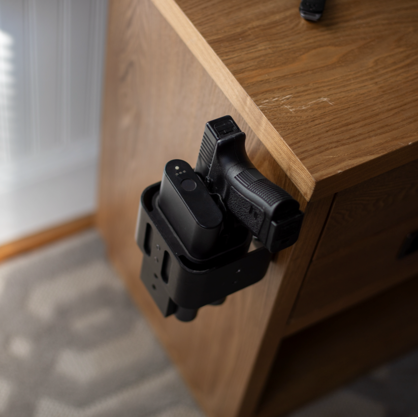 Reach 2S handgun safe mounted to the side of a nightstand with pistol secured, grip exposed for a quick draw