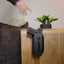 Reach Tactical handgun safe mounted on a nightstand beside a couch, holding a pistol with weapon-mounted light